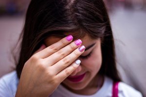 Teenager Girl looking down with hand over face - shy
