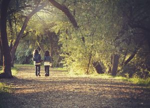 Two Children Walking Through Woods