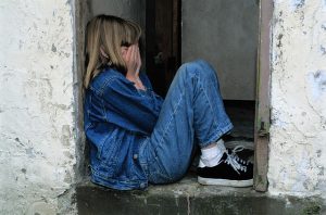 Child sitting down in doorway crying
