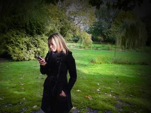 woman in park looking at iphone