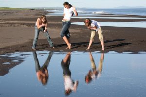 3 girls at beach - posing and looking at reflection in water