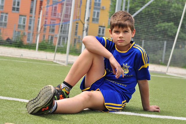 Boy relaxing on football pitch