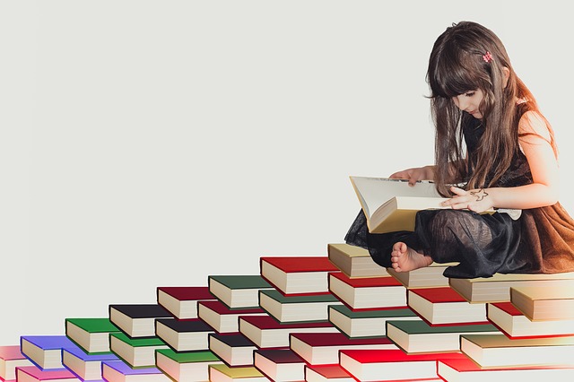 Girl sitting reading on a floor full of books
