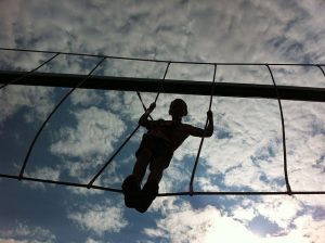 Boy climbing on high rope obstacle