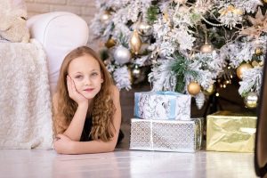 Girl under Christmas Tree with Gifts