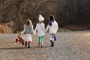3 Sisters holding hands walking outside