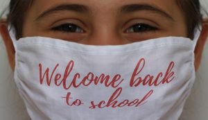 Girl with Face Mask on that says 'Welcome Back to School'