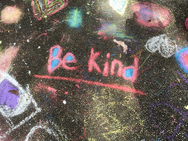 Words "Be Kind" written in chalk on floor