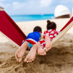 two kids lying in a hammock on the beach
