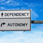 road sign with arrows pointing to dependency and autonomy