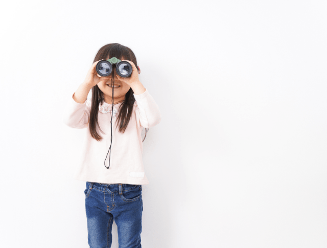 young girl looking through binoculars