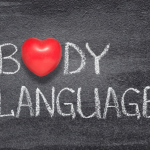 'Body Language' written in white chalk on blackboard with red heart instead of 'O'