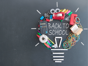 school stationery arranged in shape of lightbulb on blackboard with 'back to school' written in white chalk