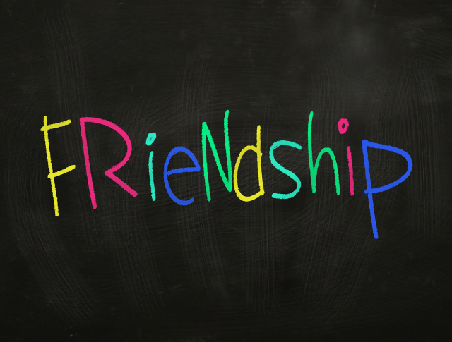 'Friendship' written with colourful chalk on blackboard