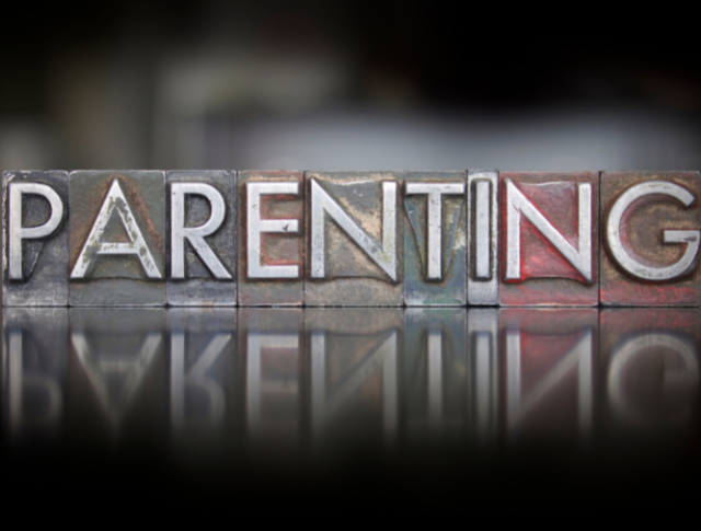 the word 'parenting' written in vintage letters and reflected underneath