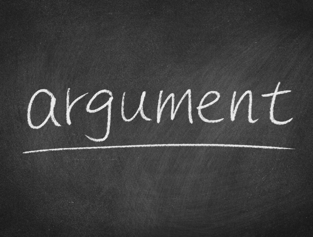 The word 'argument' written in white chalk on blackboard