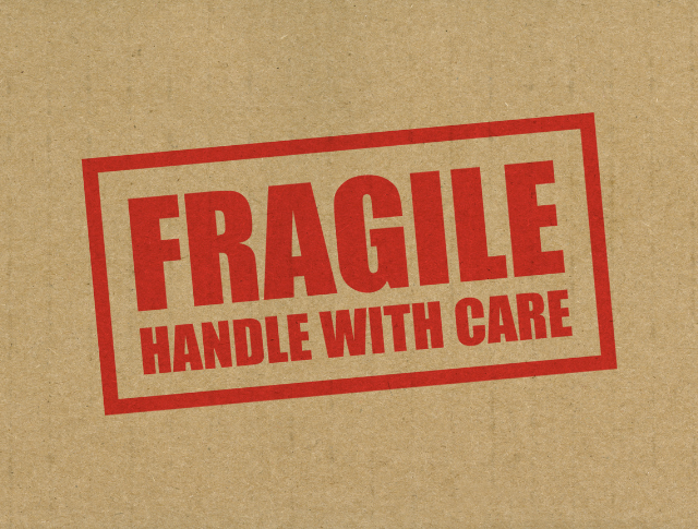 'Fragile Handle With Care' stamped on to a brown paper parcel