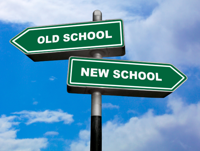 Two direction signposts, one pointing left, saying 'Old School' and one pointing right, saying 'New School'.
