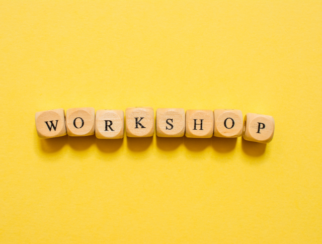 The word 'Workshop' spelled out with wooden dice on yellow background