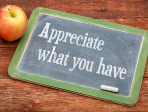 'Appreciate what you have' written in white chalk on a blackboard